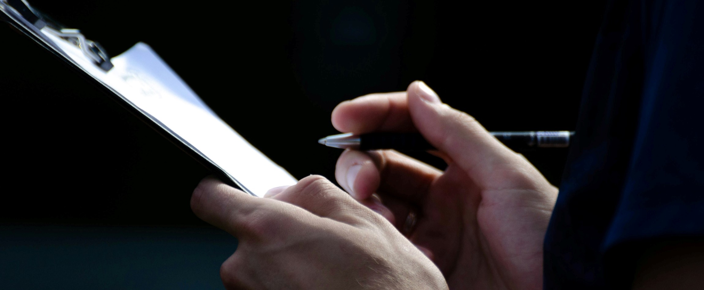 close-up of hands holding pen and clipboard