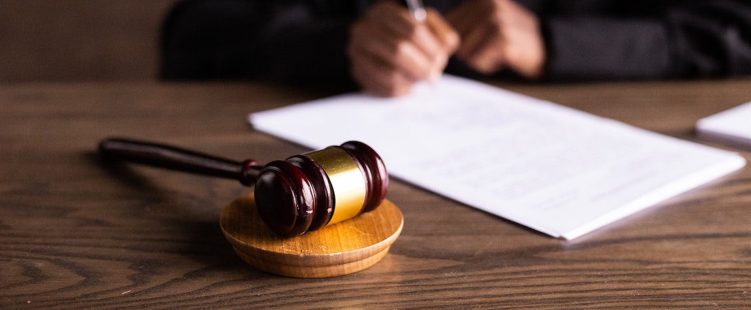 gavel and person signing papers