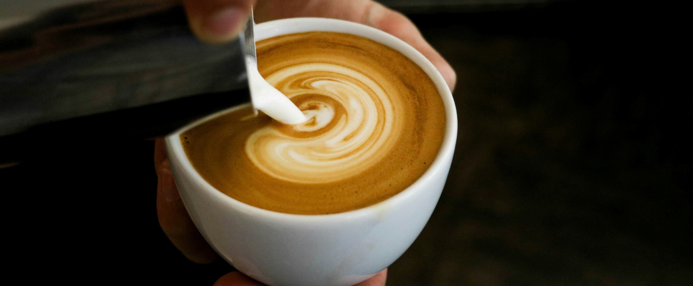 milk being poured into cappuccino