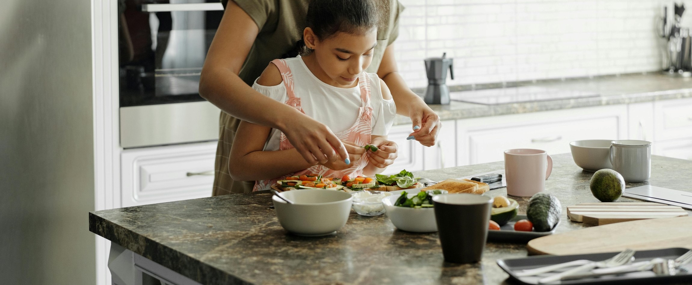 mother and daughter preparing meal together
