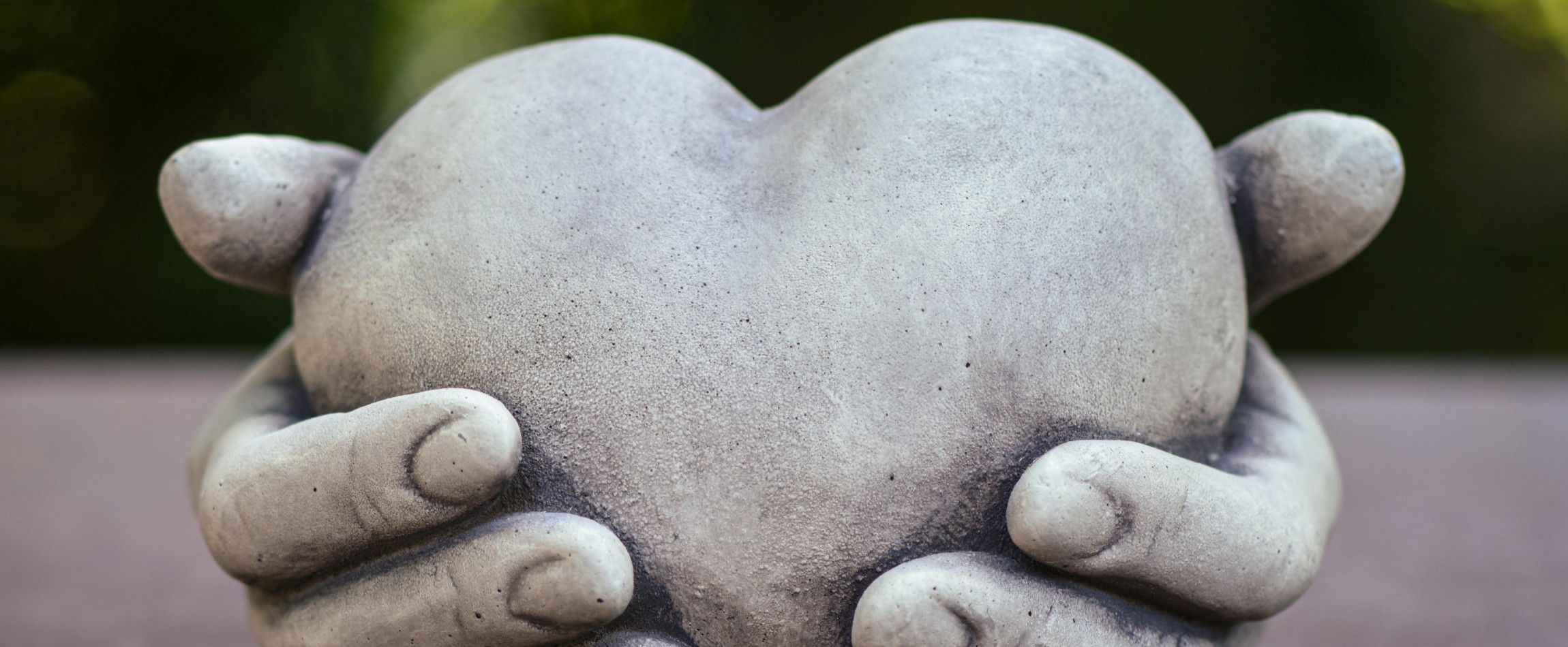 stone sculpture of two hands holding heart