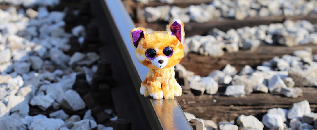 a toy cat on a railroad track